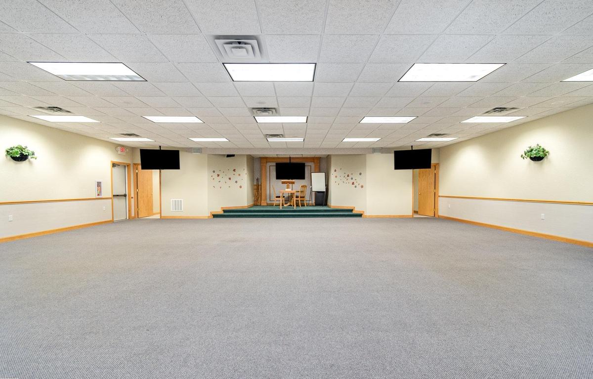The group room at Blooming Consultants, a large room with a low stage and a lectern, where the classes and workshops run.