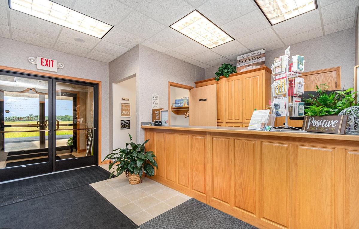 The oak reception desk at Blooming Consultants, with plants and a greeting card carousel.