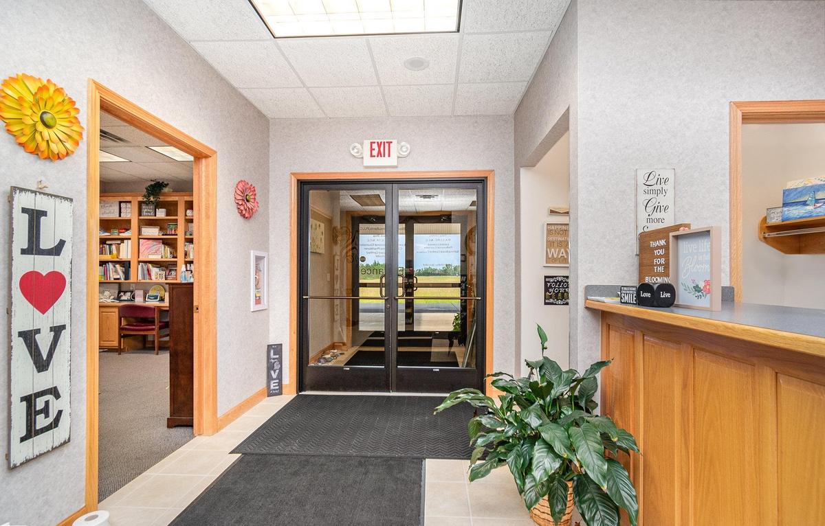 The reception hall at Blooming Consultants, with oak trim and a doorway through into a book lined room.